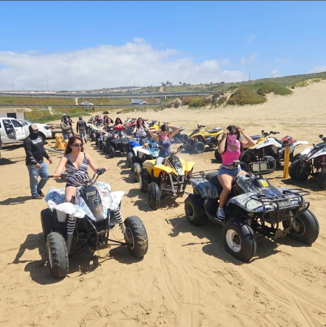 Grupo de amigos en cuatrimotos sobre la arena